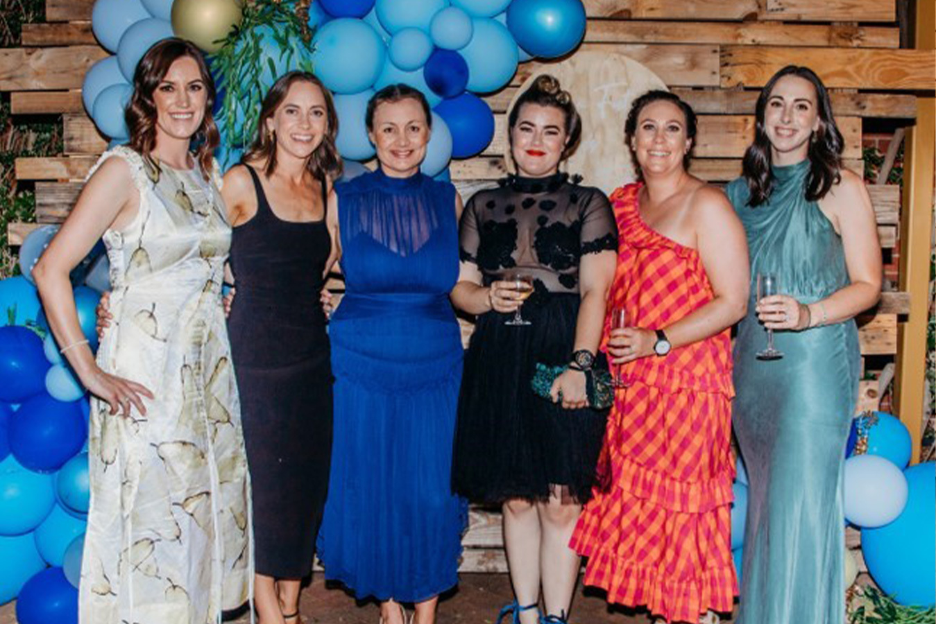 Six women wearing gowns.